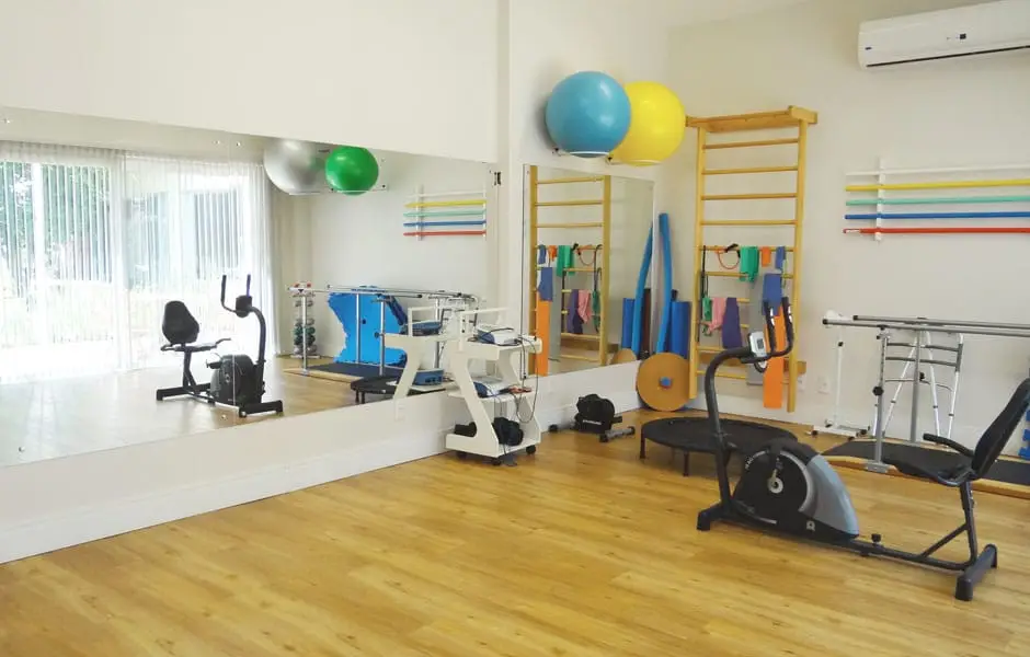 Sala de fisioterapia do Serraville com espaldar, bolas e equipamentos de reabilitação