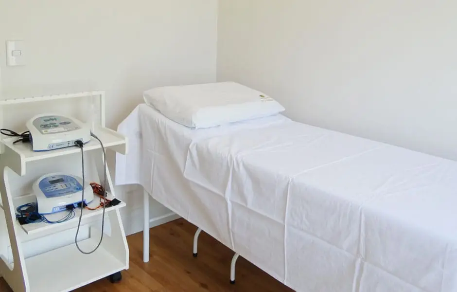 Sala de eletroterapia com maca e equipamentos