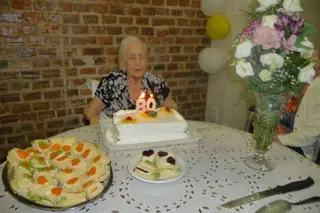 Dona Célia T. apagando as velinhas