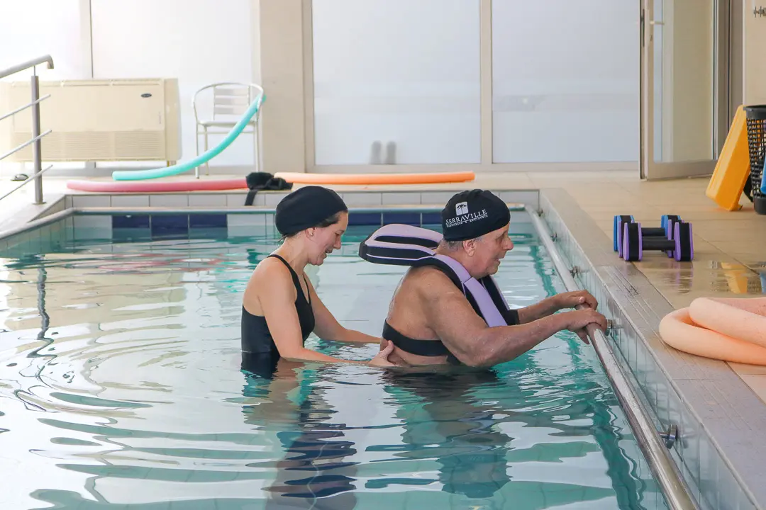 Fisioterapeuta do Serraville conduzindo sessão de hidroterapia com paciente na piscina terapêutica