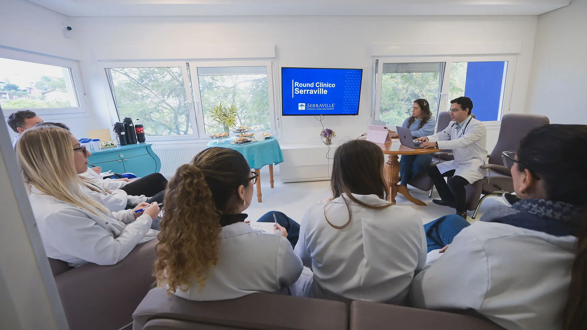 Round clínico multidisciplinar do Serraville com equipe revisando casos e condutas
